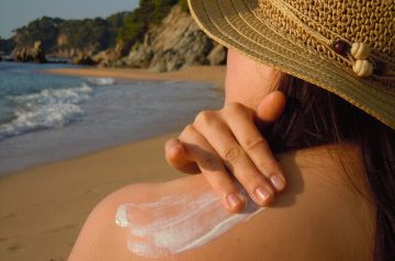 women sunbathing with sunscreen on the beach